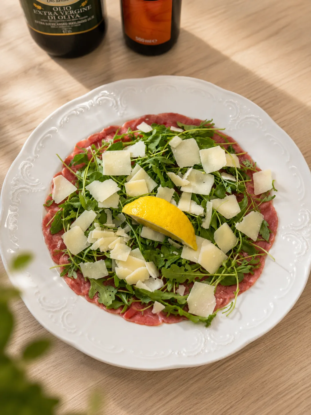 Rinder-Carpaccio mit Rucola, Parmesanspänen, Zitrone und Olivenöl